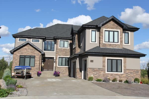 Large South West Edmonton home wrapped in a beautiful combination of stucco and stone by Met Exteriors.