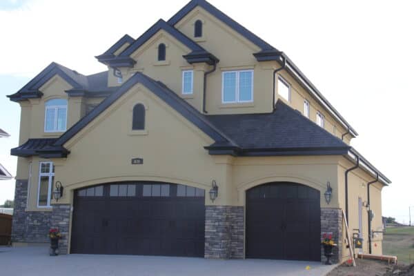 Earth toned stone and stucco exterior on a home in South Edmonton by Met Exteriors.