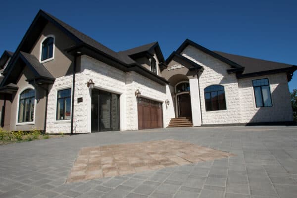 A combination of light and dark stucco and stone with fine decorative details by Met Exteriors.
