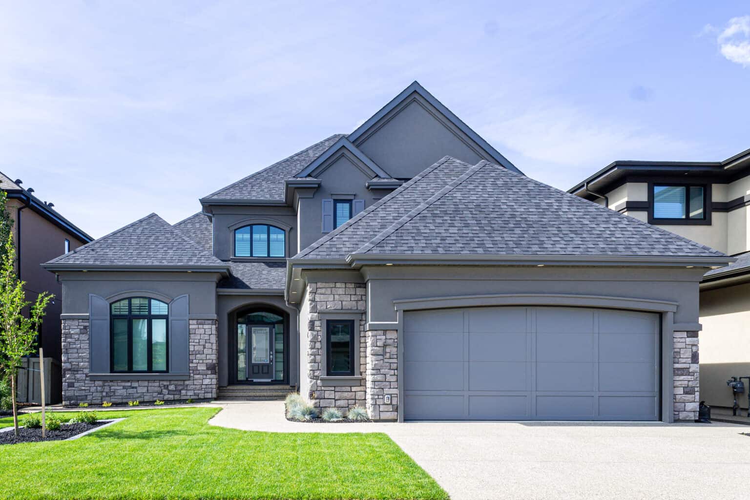 Light coloured stone and stucco on a residential home in Edmonton by Met Exteriors.