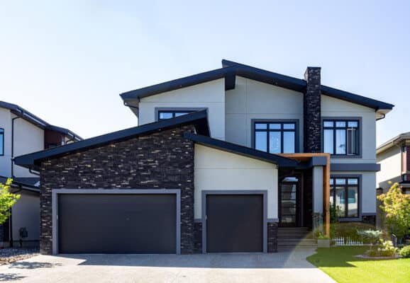 Light stucco with dark stone trim on a home in Windemere, Edmonton.
