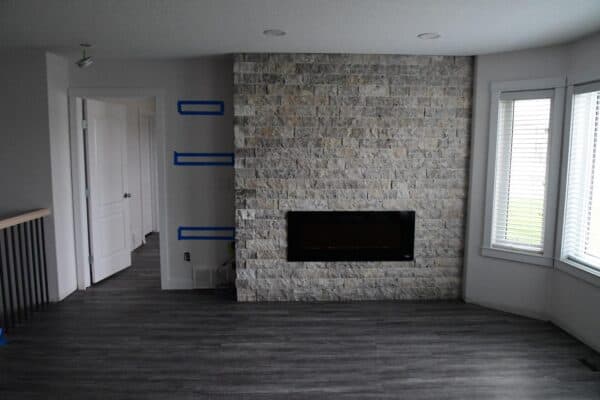 Silver travertine splitface stone on an interior fireplace by Met Exteriors.